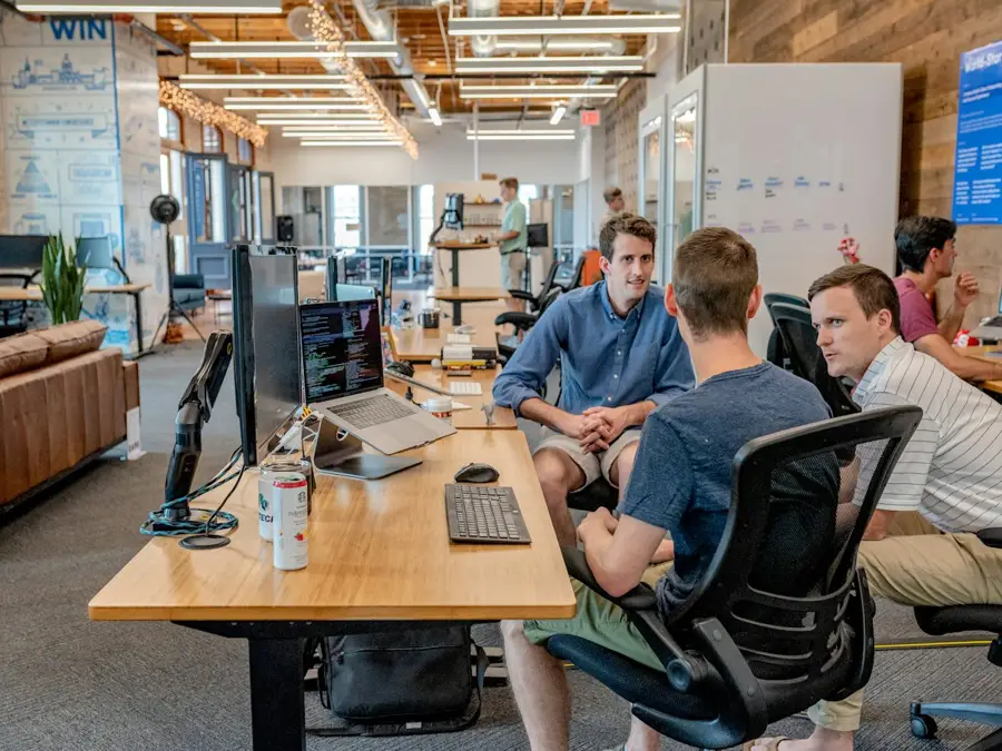 A team plans around a table with laptops and notes